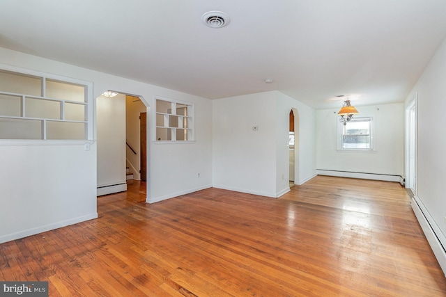 interior space featuring a baseboard heating unit and light hardwood / wood-style floors