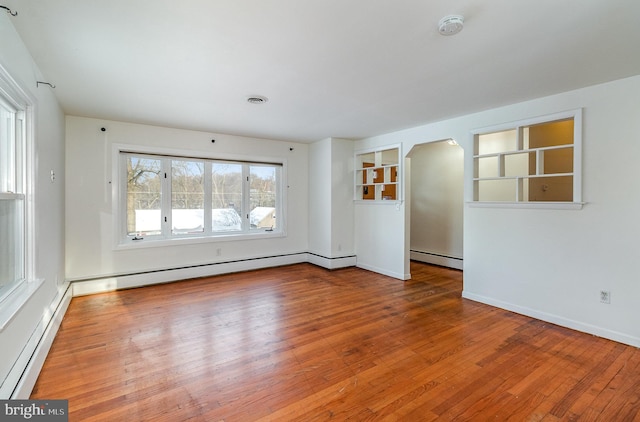 spare room featuring a baseboard radiator and wood-type flooring