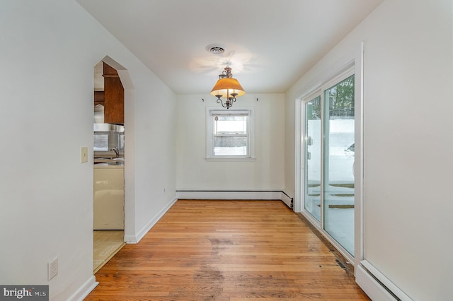 interior space featuring a baseboard heating unit, light wood-type flooring, and sink