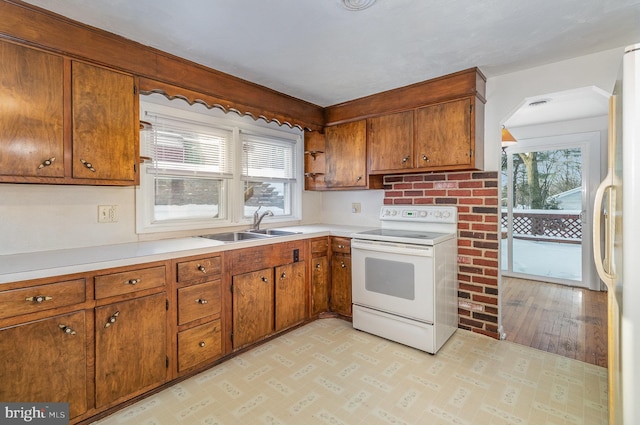 kitchen with sink, white appliances, and light hardwood / wood-style flooring