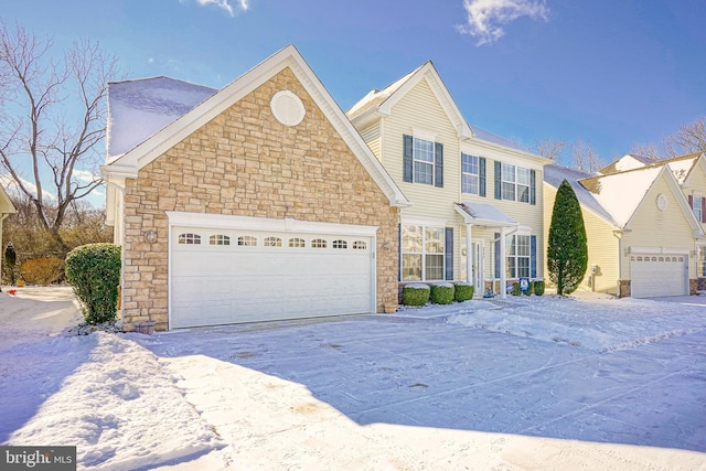 view of front of house with driveway, stone siding, and an attached garage