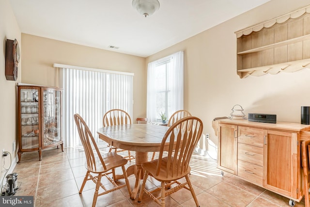 dining space featuring light tile patterned flooring and visible vents