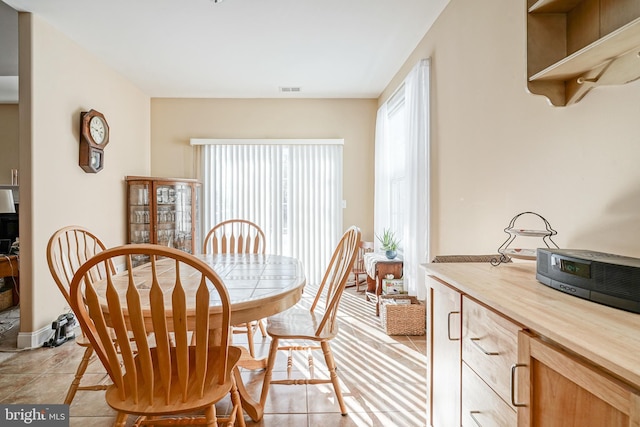 dining area with light tile patterned floors and visible vents