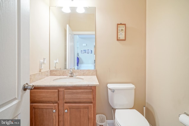 half bathroom with toilet and vanity