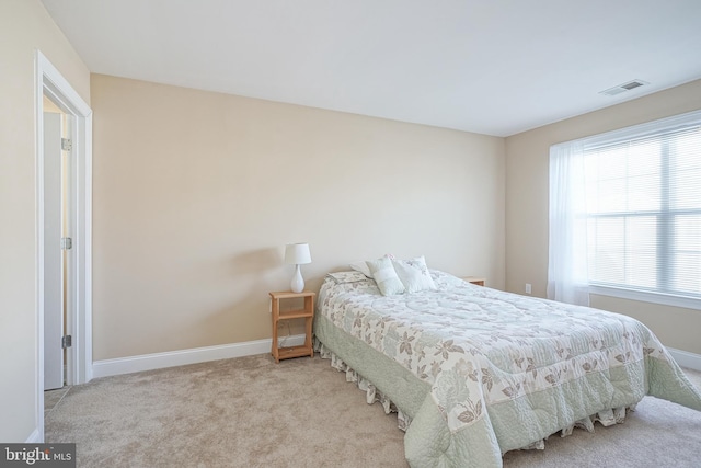 bedroom with light colored carpet, visible vents, and baseboards