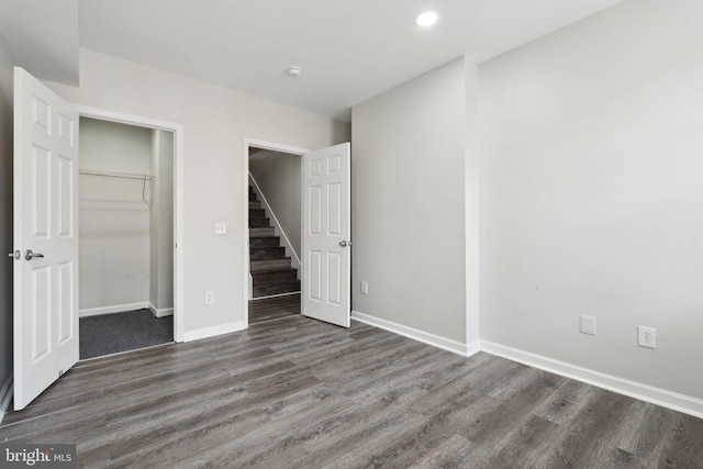 unfurnished bedroom with dark hardwood / wood-style floors and a closet