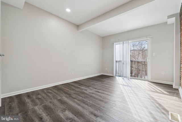 empty room with beamed ceiling and dark wood-type flooring