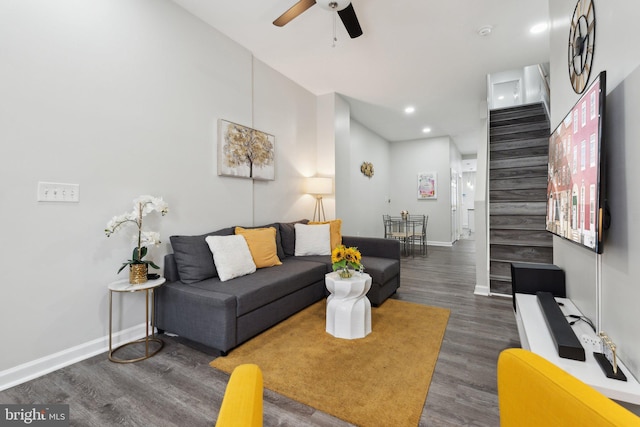 living room featuring ceiling fan and dark hardwood / wood-style floors