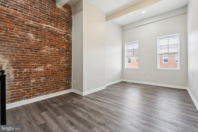 interior space featuring dark wood-type flooring and brick wall