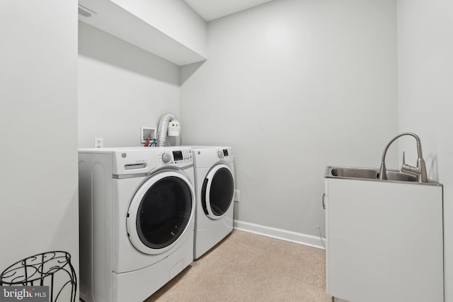 clothes washing area with washer and clothes dryer and sink