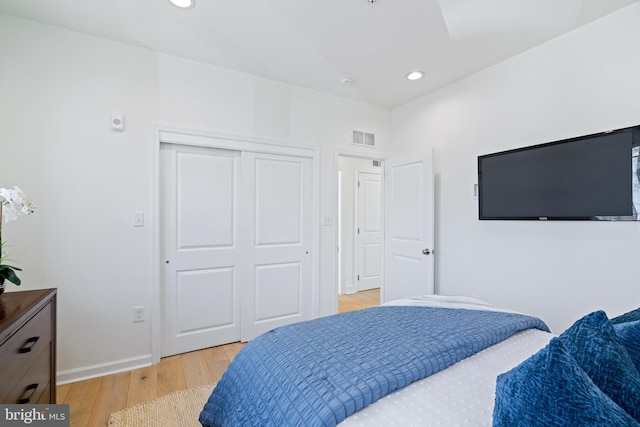 bedroom with light wood-type flooring and a closet