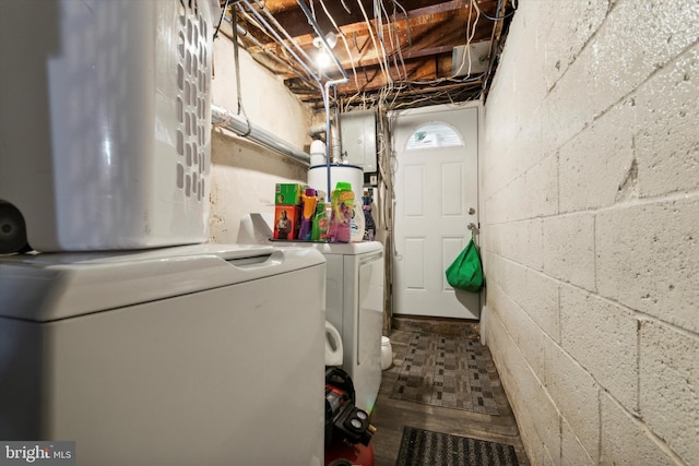 clothes washing area with electric panel, separate washer and dryer, and water heater