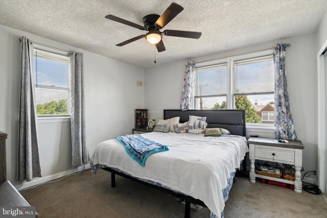 carpeted bedroom featuring ceiling fan and a textured ceiling