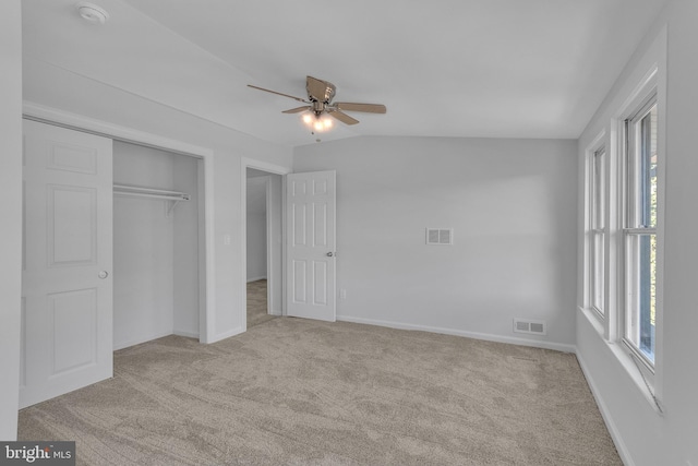 unfurnished bedroom with ceiling fan, lofted ceiling, light carpet, and a closet