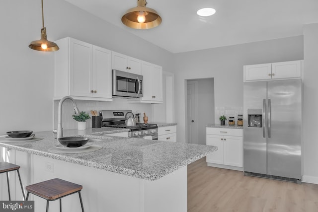 kitchen with white cabinets, kitchen peninsula, and stainless steel appliances