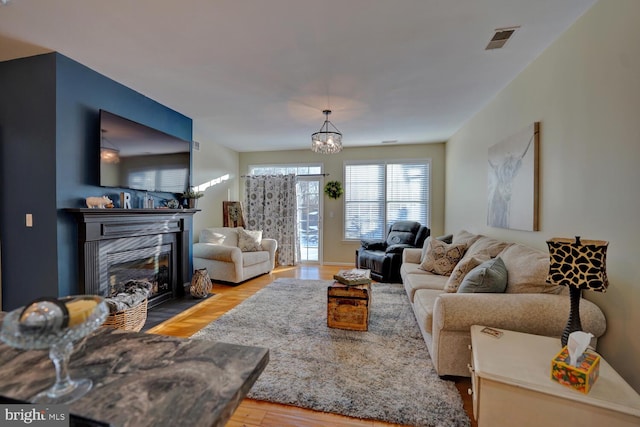 living room featuring light hardwood / wood-style floors and an inviting chandelier