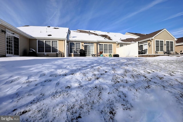 view of snow covered rear of property