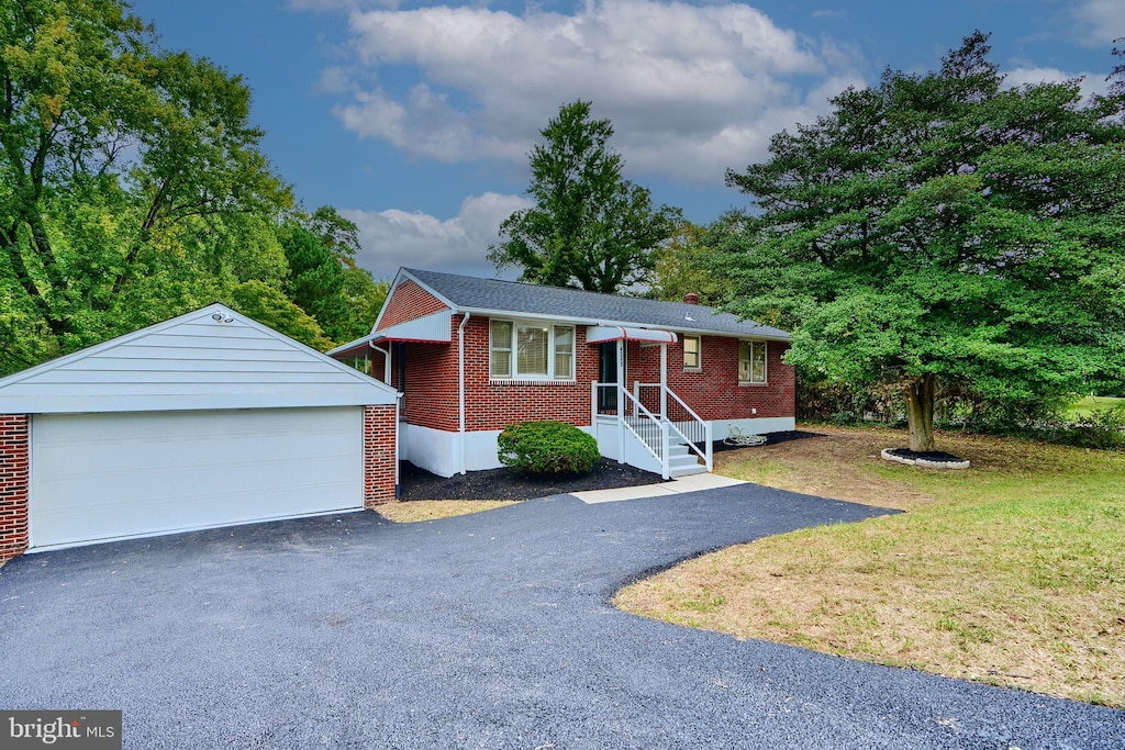 single story home with an outbuilding, a front lawn, and a garage