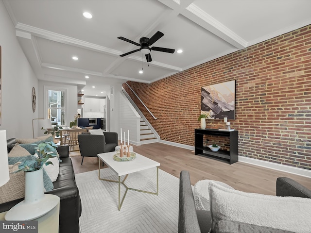 living room featuring light hardwood / wood-style floors, brick wall, beam ceiling, and ceiling fan