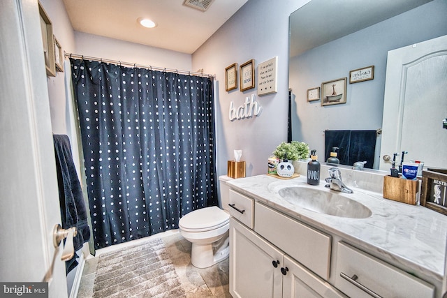 bathroom featuring vanity, toilet, and walk in shower