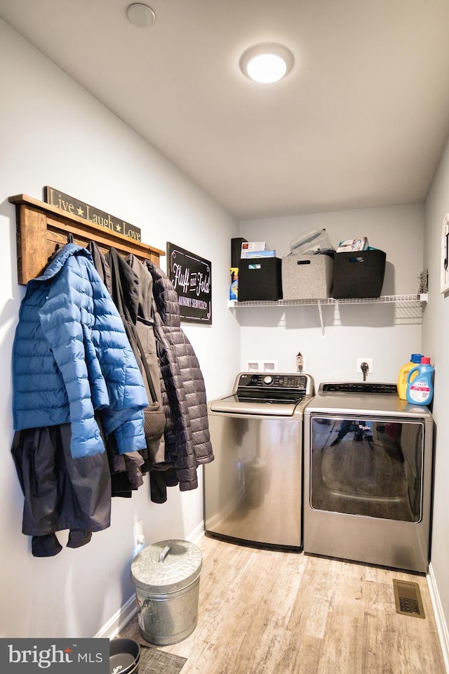 laundry area with washing machine and clothes dryer and hardwood / wood-style floors