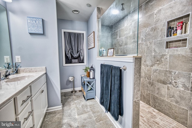 bathroom featuring a tile shower and vanity