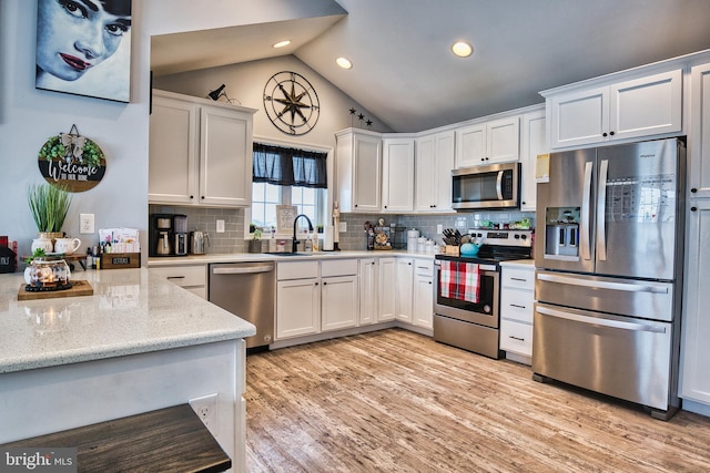 kitchen featuring white cabinets, backsplash, stainless steel appliances, and sink