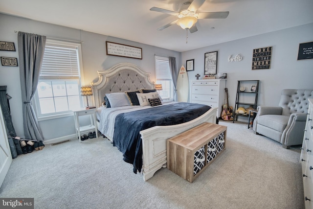 bedroom with ceiling fan, light carpet, and multiple windows