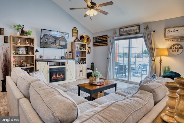 living room with ceiling fan, lofted ceiling, and light wood-type flooring