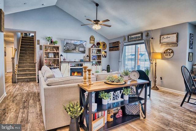 living room with ceiling fan, hardwood / wood-style floors, and lofted ceiling