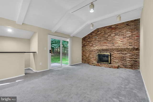 unfurnished living room with lofted ceiling with beams, carpet floors, brick wall, and a brick fireplace