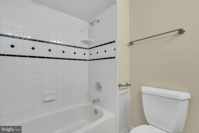 bathroom featuring toilet and tiled shower / bath