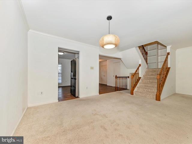 unfurnished living room with crown molding, carpet floors, and vaulted ceiling