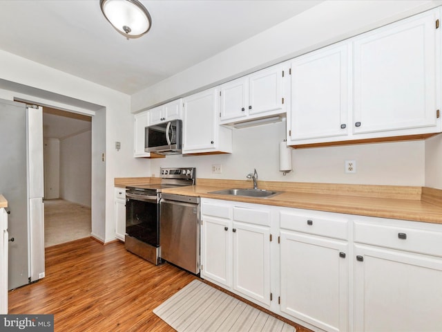 kitchen with white cabinets, sink, and stainless steel appliances