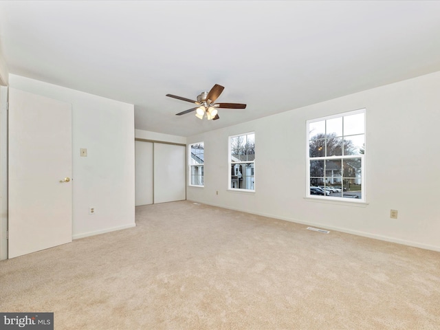 carpeted spare room with ceiling fan