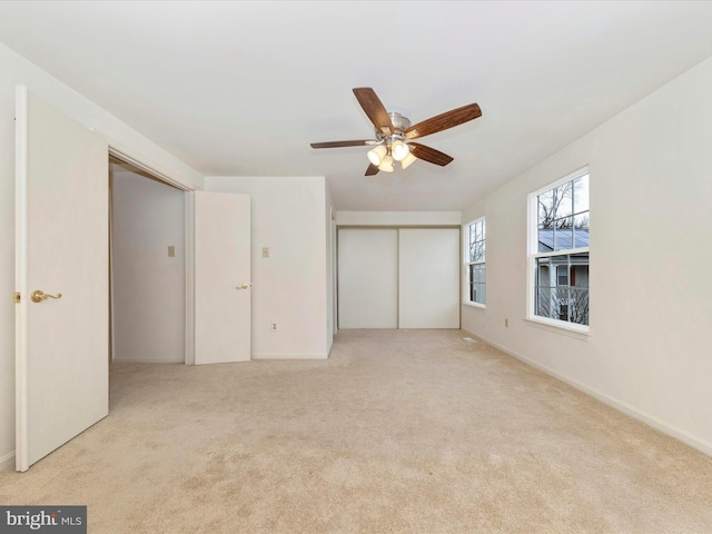 unfurnished bedroom with ceiling fan and light carpet