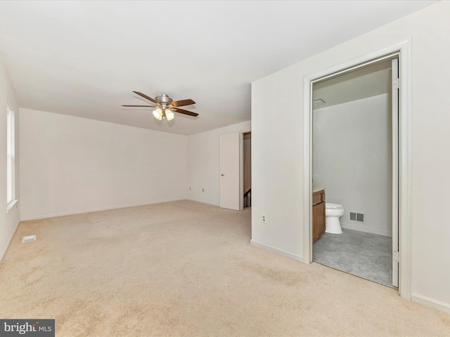 unfurnished bedroom featuring ensuite bathroom, ceiling fan, and light colored carpet