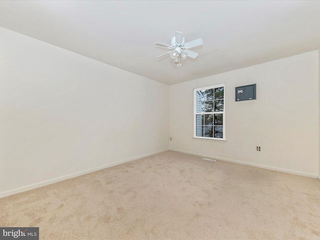 spare room with ceiling fan and light colored carpet