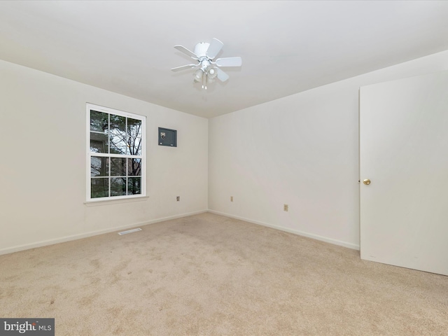 spare room with ceiling fan and light colored carpet