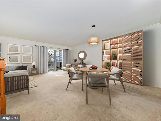 dining area featuring crown molding and light colored carpet