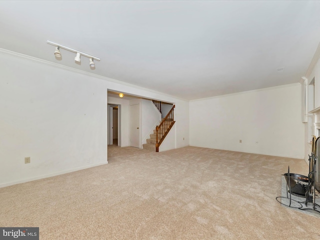 unfurnished living room with light carpet, track lighting, and ornamental molding