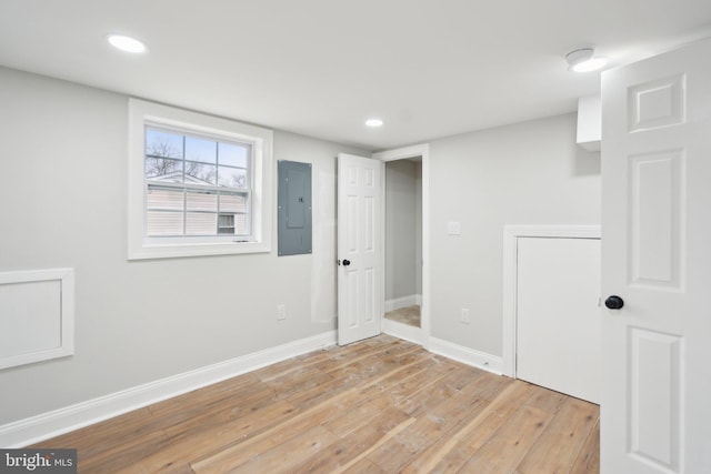 empty room featuring electric panel and light wood-type flooring