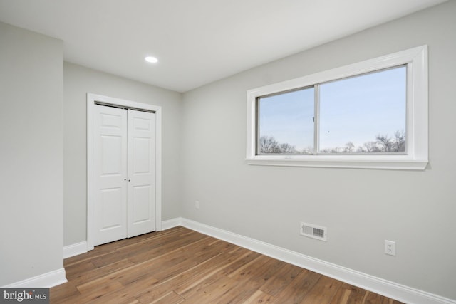 unfurnished bedroom with wood-type flooring and a closet