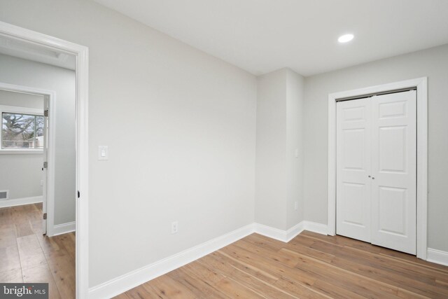 unfurnished bedroom with hardwood / wood-style floors and a closet