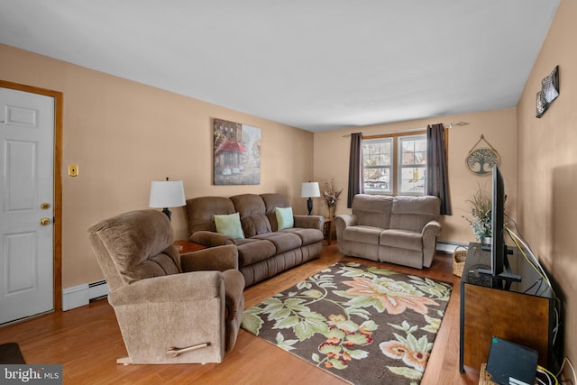 living room with light hardwood / wood-style floors and a baseboard heating unit