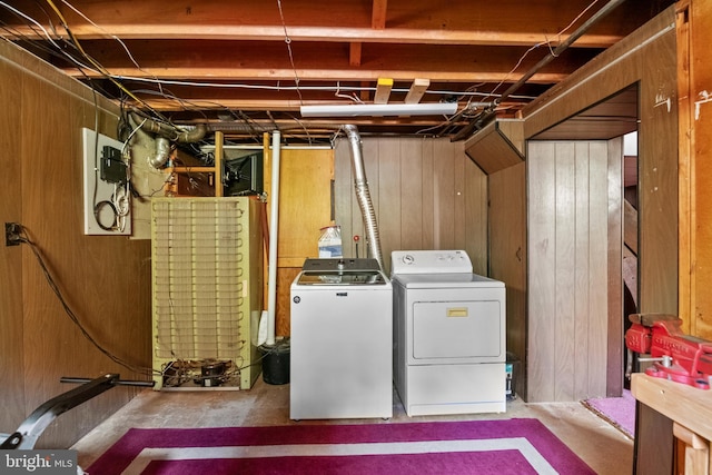 laundry area with wood walls and washing machine and clothes dryer