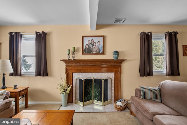 living room with beam ceiling, light colored carpet, and a fireplace