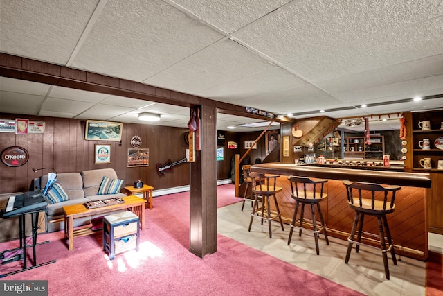 bar featuring a baseboard heating unit, wood walls, and a paneled ceiling