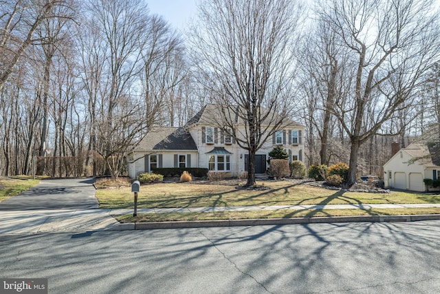 view of front of property featuring a front lawn, a garage, and driveway