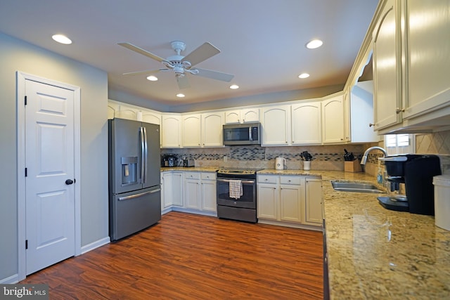 kitchen featuring dark wood-type flooring, sink, ceiling fan, stainless steel appliances, and decorative backsplash